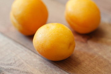 Delicious ripe apricots in a wooden bowl on the table close-up. Horizontal view from above