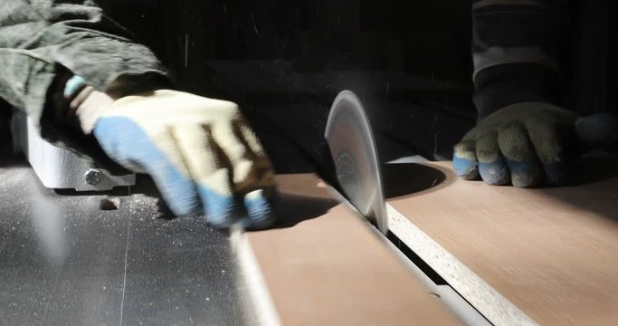 Close-up of a circular saw cuts the particle wooden board.