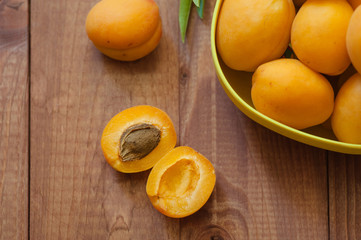Naklejka na ściany i meble Organic apricots with leaves on wooden background