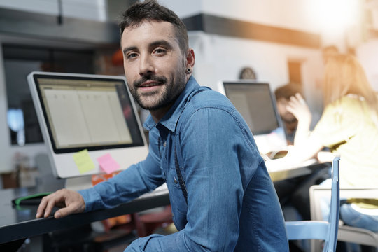 Startup entrepreneur sitting in office in front of desktop