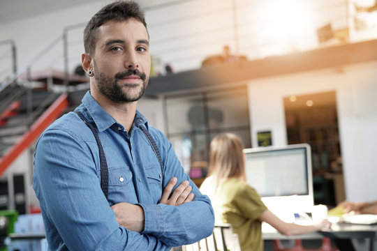 Modern guy in startup office with arms crossed