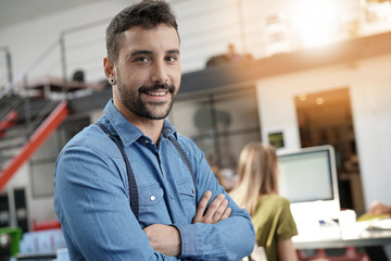 Modern guy in startup office with arms crossed
