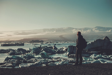 Woman explorer lookig at Jokulsarlon lagoon, Iceland.