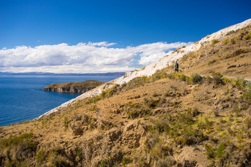 Fototapeta na wymiar Backpacker exploring the inca's majestic footpaths on Island of the Sun, Titicaca Lake, scenic travel destination in Bolivia. Travel adventures and vacations in the Americas.