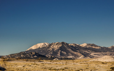 Mountain landscape with clear blue sky and a snow covered mountain