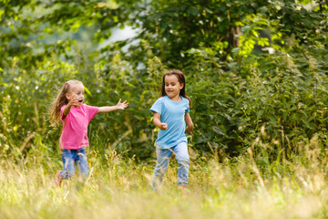 Fototapeta premium Two little ones running around holding hands in the park