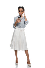 Shocked african american woman using smartphone isolated on white