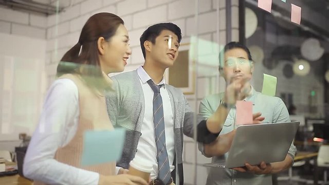 a team of three asian entrepreneur discussing business in office.  