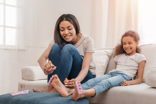 Happy African American Mother And Daughter Doing Pedicure Together At Home