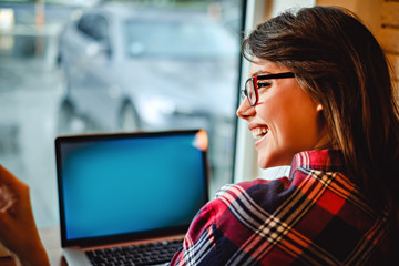 Girl with glasses laughing in front of computer