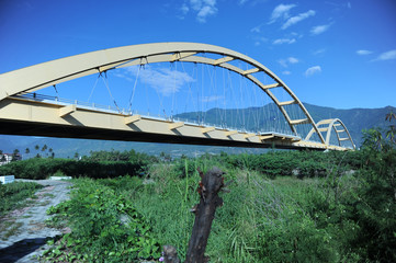 INDONESIA, JAN 8, 2017 : Panulele Bridge, Is a landmark icon of the city of Palu. This yellow bridge is the first arch bridge in Indonesia and the third in the world after in Japan and France