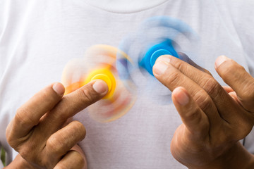 Blue and yellow spinners both in hands.