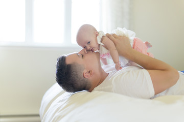Portrait of father with her 3 month old baby in bedroom