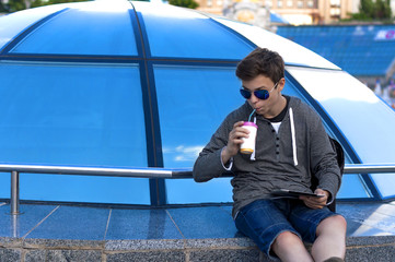 young man with a tablet near a blue glass dome