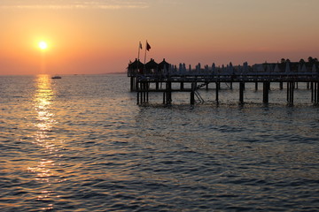 Fototapeta premium sunset on the beach, romantic time, lovelu sky, ocean, dusk, clouds, romantic, lovely , bridge, colors, 