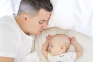 Portrait of father with her 3 month old baby in bedroom sleeping