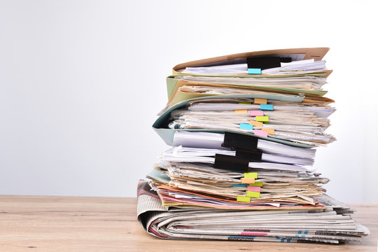 Stack documents pace on wood desk in office