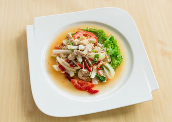 Thai salad with glass noodles prawns and peanuts on top with Chicken meat in a bowl close-up, Spicy Salad(Yum Woon Sen)