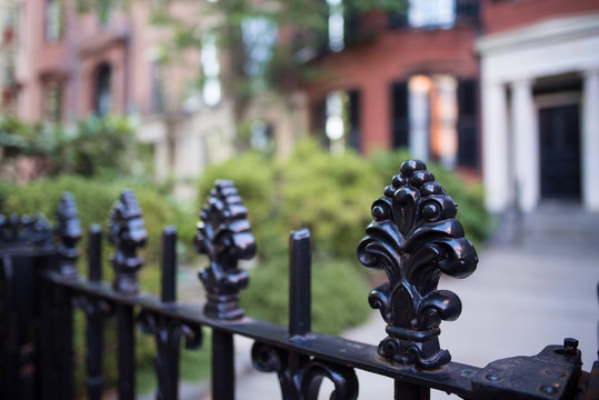 Beautiful Wrought Iron Fence With Carved Posts In An Old Colonial Neighborhood In New England.