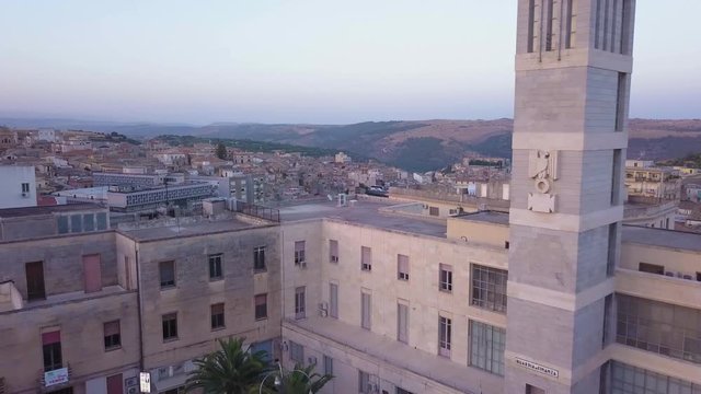 flying backwards past fascist symbol on Guardia di Finanza tower in Ragusa