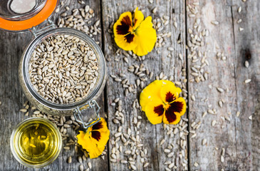 Obraz na płótnie Canvas Sunflower oil and sunflower seeds in jar on wooden table