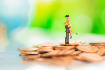 Miniature couple : Lovers embrace love on the stack coin.