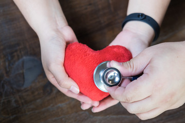 Red heart shape in asian woman's hands and stethoscope , concept of Valentine's day and healthcare