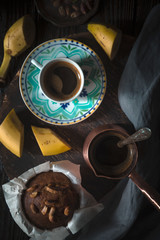 Flavored banana cupcake and cup of coffee on the wooden table