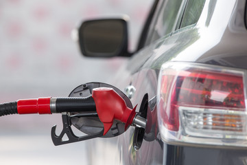 The car at the gas station is refueled with gasoline