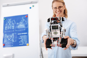 Fototapeta na wymiar Friendly scientist demonstrating new self automatic robot indoors