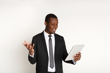 Smiling african american businessman using tablet.