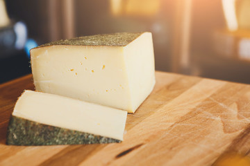 Hard cheese as pieces on wooden table closeup