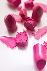 Cut pink lipsticks closeup on white background. Cosmetics commercial, beautiful style. Exquisite smear, glamorous magazine, creative advertising, beauty concept
