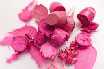 Pink lipstick chopped closeup on white background. Cosmetics commercial, beautiful style. Expensive smear, creative advertising, beauty concept
