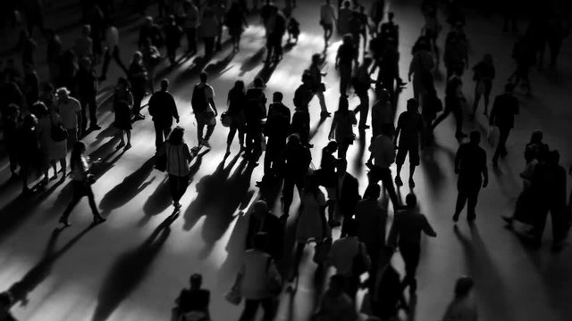 crowd of people walking on busy street commuting through the city metropolis 