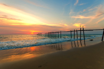 Evening light during sunset on the sea with an old wooden bridge.