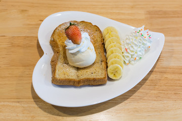 Iced cream toast with strawberry and bananana on table