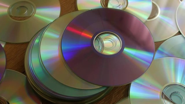 Optical Discs falling onto big pile of DVDs or CDs.