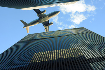 Flugzeug fliegt über Hochhäuser von unten