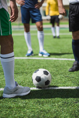 partial view of group of soccer players during soccer match on pitch