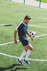 side view of soccer player kicking ball  while training on soccer pitch © LIGHTFIELD STUDIOS