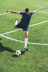 athletic soccer player kicking ball on soccer pitch © LIGHTFIELD STUDIOS