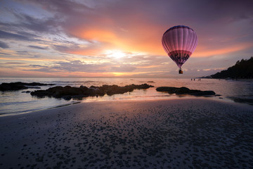 Fototapeta na wymiar Beach sunset and Colorful hot air balloon on sunset sky.