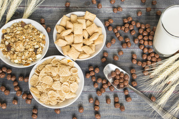 Various cold cereals on the dark wooden background.