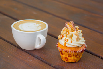 Caramel nut cupcake and cup of coffee