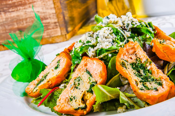 Salad leaves with rolls of salmon and spinach