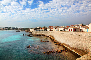 Fototapeta na wymiar Seawall and harbor of Antibes in Southern France