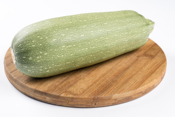 Fresh whole zucchini on the wooden kitchen board