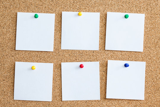 Six white memo reminder cards pinned to cork board. Blank empty copy space square papers background.
