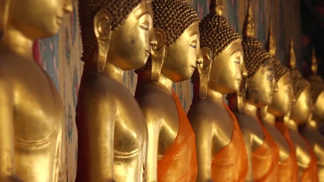 Row of golden buddha statues at Wat Arun temple in Bangkok, Thailand 